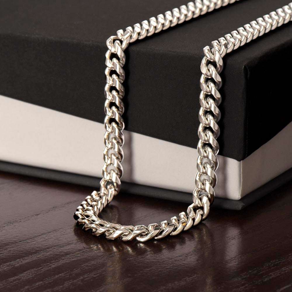 Close-up of a polished Valor Cuban Link Chain in stainless steel and 14K yellow gold with adjustable length and parrot clasp